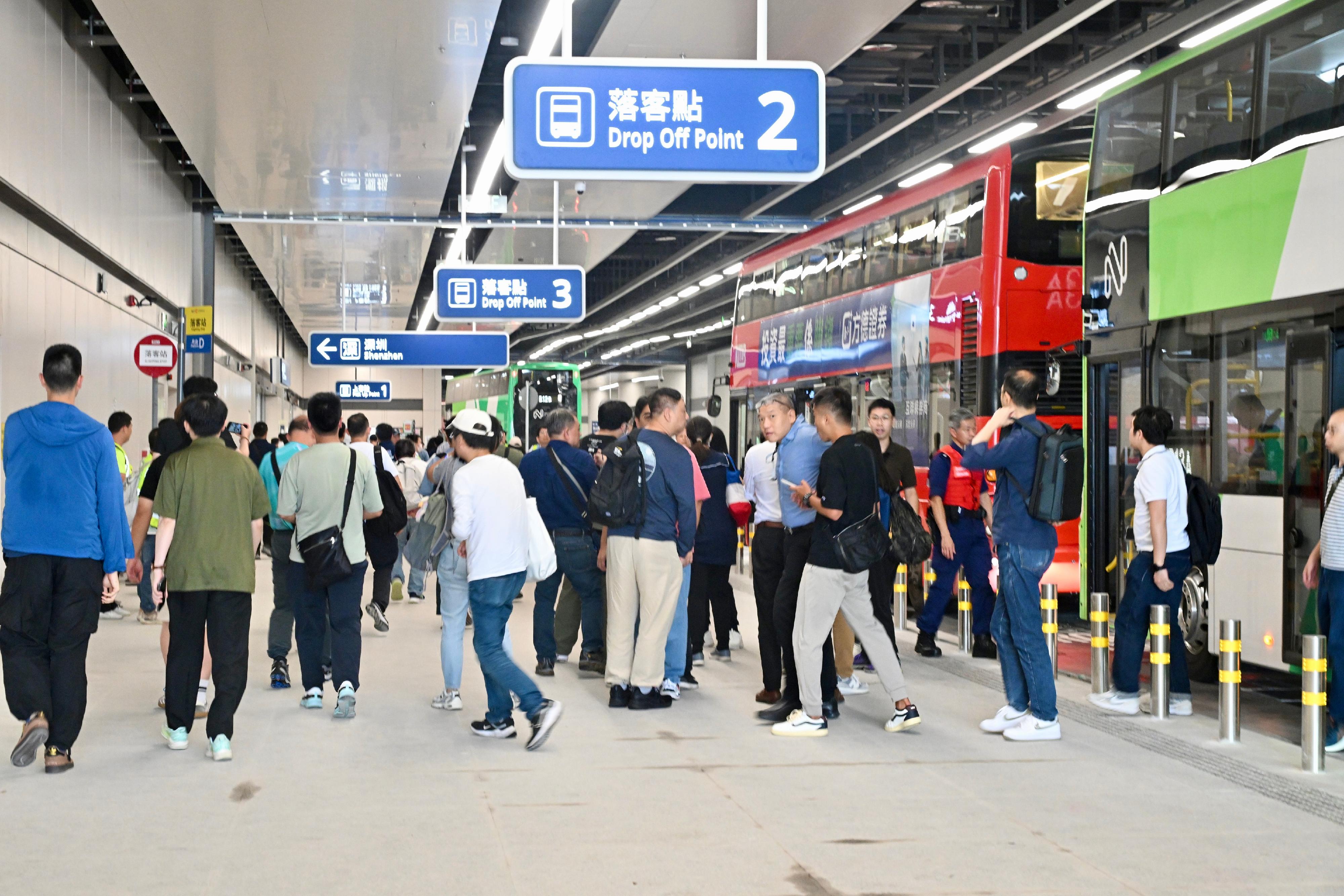 皇岗口岸港方口岸区举行首次大型演练(图2) 香港特别行政区政府今日(八月十三日)于皇岗口岸港方口岸区举行大型演练,为日后口岸正式开通作好准备。图示不同部门的公务员按指示乘搭不同公共交通工具抵达位于联检大楼二楼的公共运输交汇处。